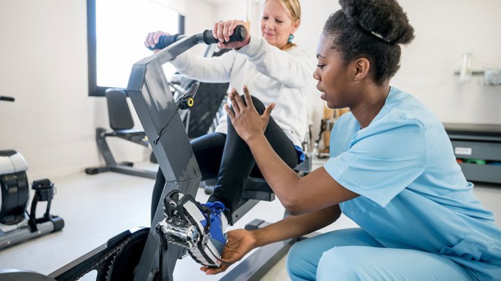 pulmonary rehab patient on exercise bike with rehab specialist